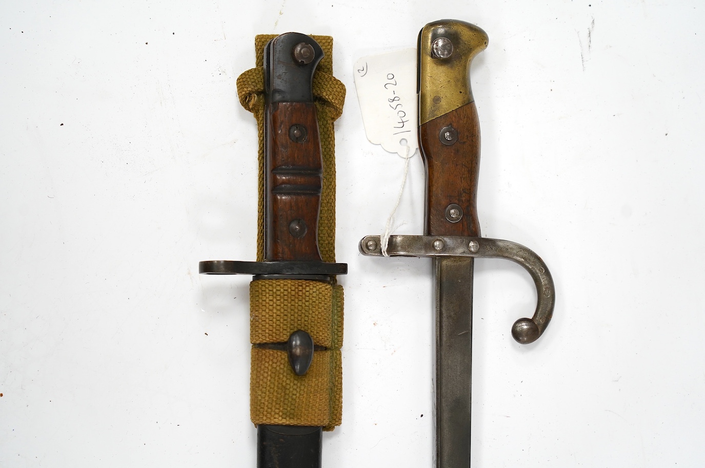 Two bayonets; a good Remington bayonet dated 1913 in its leather scabbard with khaki frog dated 1940, and a Gras bayonet dated 1880. Condition - good